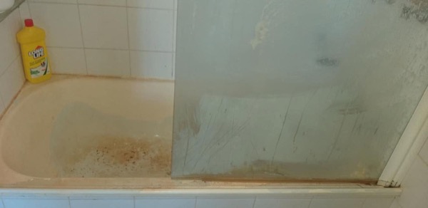 The same bath and shower screen with clouded glass and marking around the rim