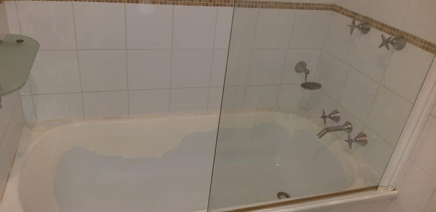 A bathtub, wall tiles and a shower screen in a bathroom