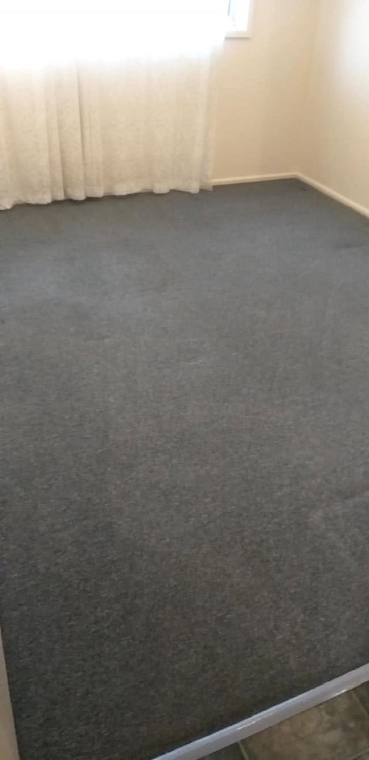 Grey carpet and sheer curtains in a room cleaned by The Complete Cleaning